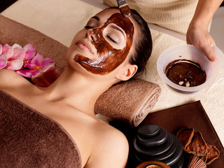 Spa therapy for woman receiving cosmetic mask