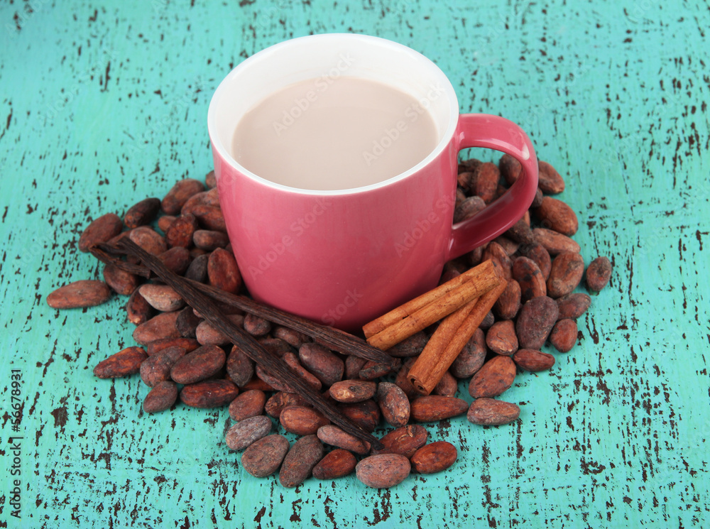 Cocoa drink  with spices and cocoa beans on wooden background