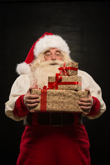 Wall Mural - Santa Claus carrying big stack of Christmas gifts