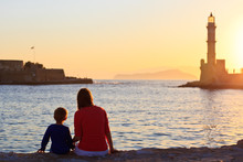 Family Looking At Lighthouse In Greece At Sunset
