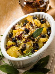 baked potatoes with dried tomatoes and black olives