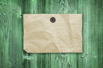 Wall Mural - Empty paper ad hanging on green wooden wall