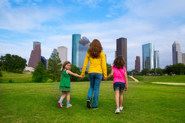 Fototapete - Mother and daughters walking holding hands on city skyline