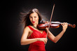 Young woman in red dress playing the violin