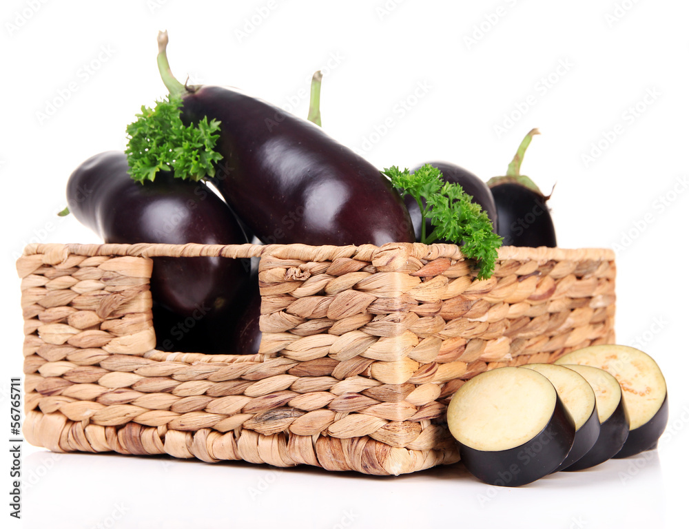 Fresh eggplants in wicker basket isolated on white