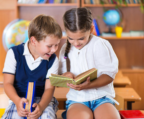 Canvas Print - Two happy schoolchildren have fun in classroom