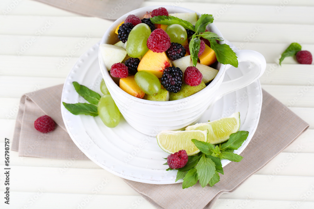 Fruit salad in cup on wooden table