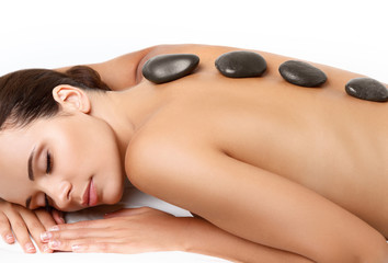 Stone Massage. Beautiful Woman Getting Spa Hot Stones Massage in