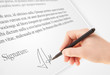 © ra2 studio - Hand writing personal signature on a paper form