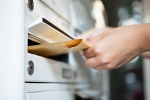 Woman Putting Envelope In Mailbox