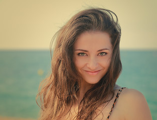 Beautiful smiling woman with long hair looking on beach backgrou