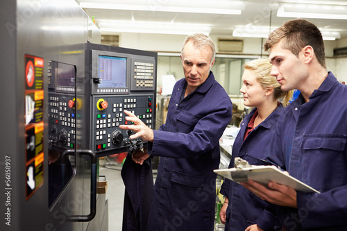 Fotografie, Obraz Engineer Teaching Apprentices To Use Computerized Lathe