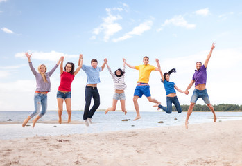 Wall Mural - group of friends jumping on the beach