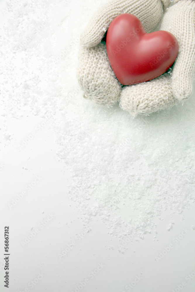 Female hands in mittens with red heart, close-up