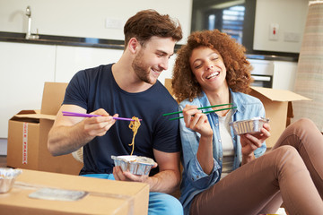 Wall Mural - Couple Moving Into New Home Enjoying Takeaway Meal