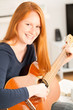 © ptnphotof - Happy Woman with a Guitar at Home