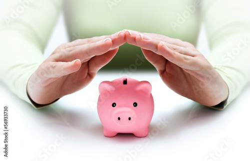 Fotografia protect your savings - with his hands covering the piggy bank