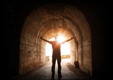 Man stands inside of old dark tunnel