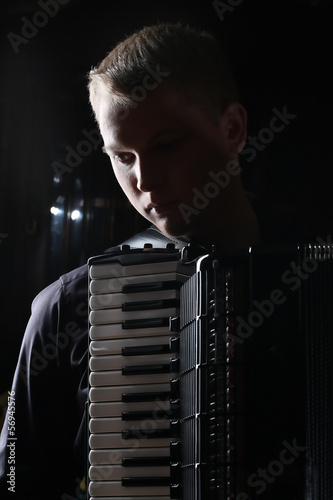 Fényképezés musician plays the accordion against a dark background