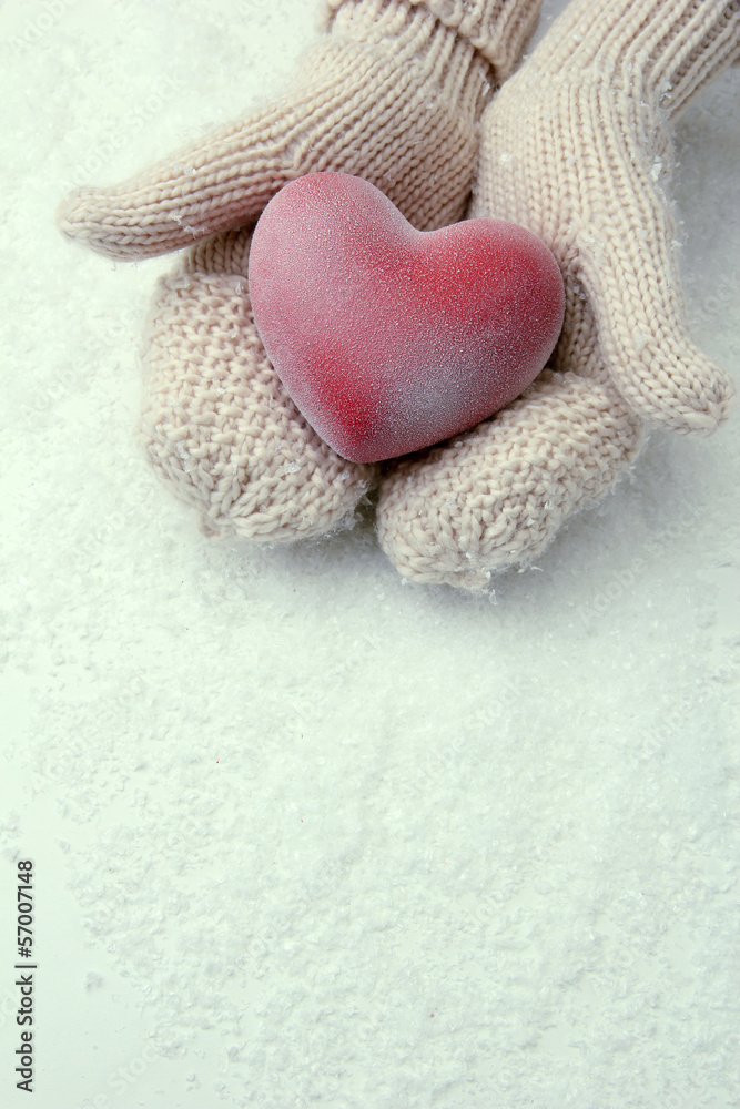 Female hands in mittens with red heart, close-up