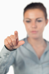 Portrait of a serious businesswoman pressing an invisible key