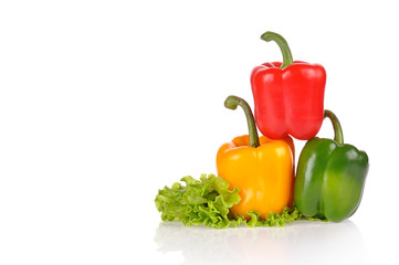 Red Green and Yellow peppers on salad leaf isolated on white bac