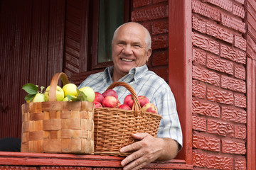 Poster - elderly man with   baskets of apples