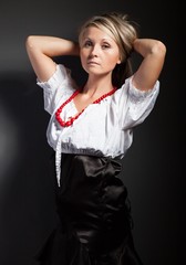 Folk woman in folklore clothes braiding a plait