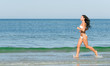 © M-Production - Sensual brunette running on the beach. Place for text.