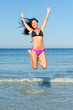 © M-Production - Happy woman jumping in the water at the beach