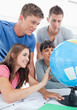 © WavebreakmediaMicro - Close up of four people looking at the globe of the world
