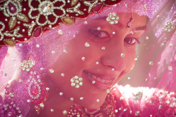 Young beautiful indian bride looking through veil