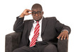 © sixdays - Black male model pondering while sitting is chair wearing a suit