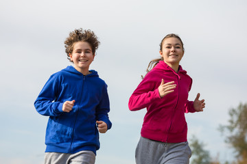 Wall Mural - Healthy lifestyle - girl and boy running, jumping outdoor