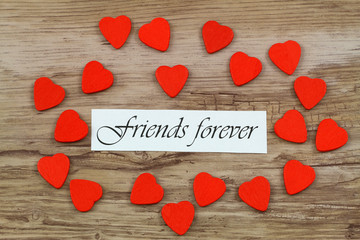 Wall Mural - friends forever card with little wooden hearts on wooden surface