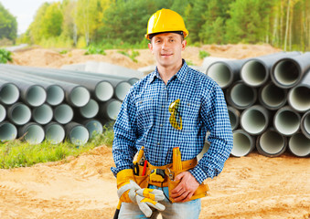 Wall Mural - worker near stack of big pipes