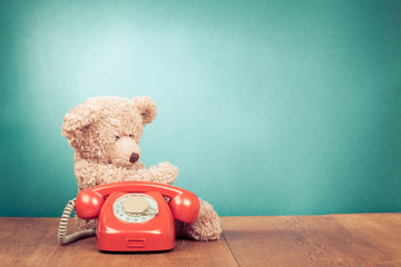 Fototapete - Retro red telephone and Teddy Bear near mint green wall