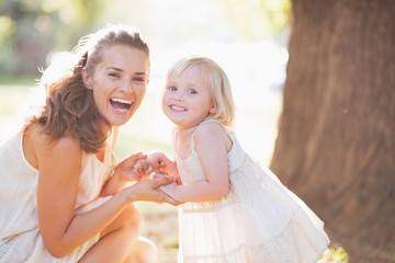 Wall Mural - Portrait of happy mother and baby in park