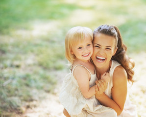 Wall Mural - Portrait of smiling mother and baby outdoors