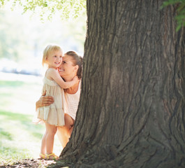 Wall Mural - Happy mother and baby near tree