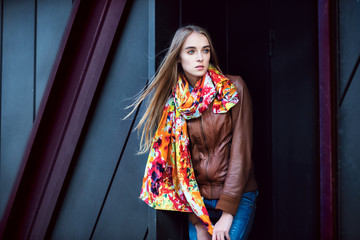 Wall Mural - Beautiful fashion woman wearing leather coat and scarf posing