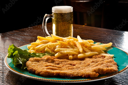 Fotografía cotoletta alla milanese con patate fritte e birra