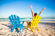 © travnikovstudio - Young woman in beach chair raised her hands up on white beach