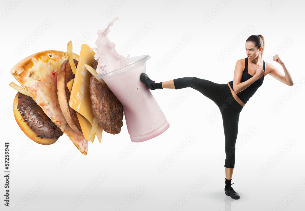 Fit young woman fighting off fast food - obrazy, fototapety, plakaty 