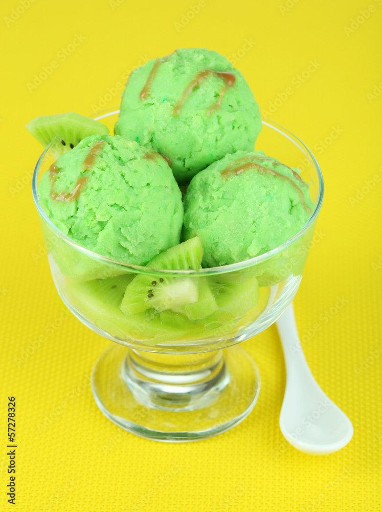 Delicious ice cream on glass vase on yellow tablecloth