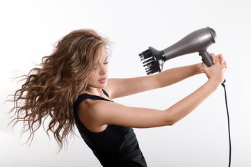 girl dries long hair with hairdryer