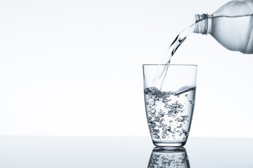 water flowing from plastic bottle into a glass