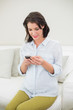 © lightwavemedia - Pretty pregnant brown haired woman using her mobile phone