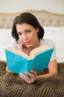 © lightwavemedia - Pensive pretty brown haired woman reading a book