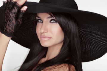 Fashion brunette woman model posing in black hat isolated on whi